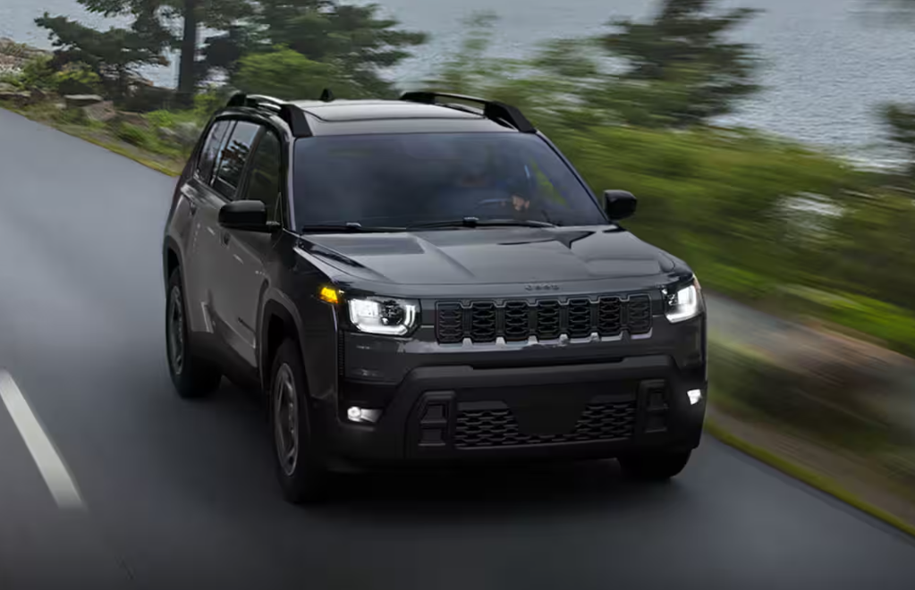 Black 2026 Jeep Cherokee driving on road
