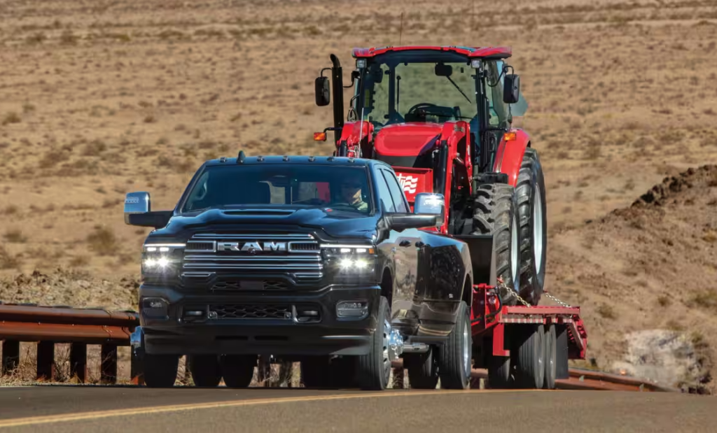 Black 2026 Ram 3500 towing a tractor