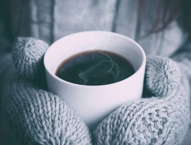 Person holding a white ceramic mug